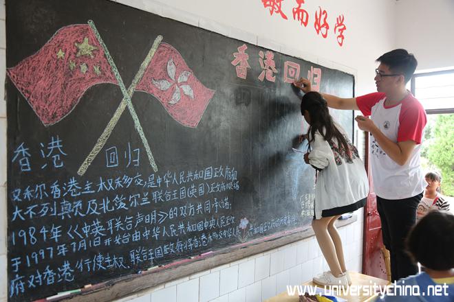 7.孩子们和志愿者一起绘制“建党96周年暨香港回归20周年”主题黑板报。.jpg