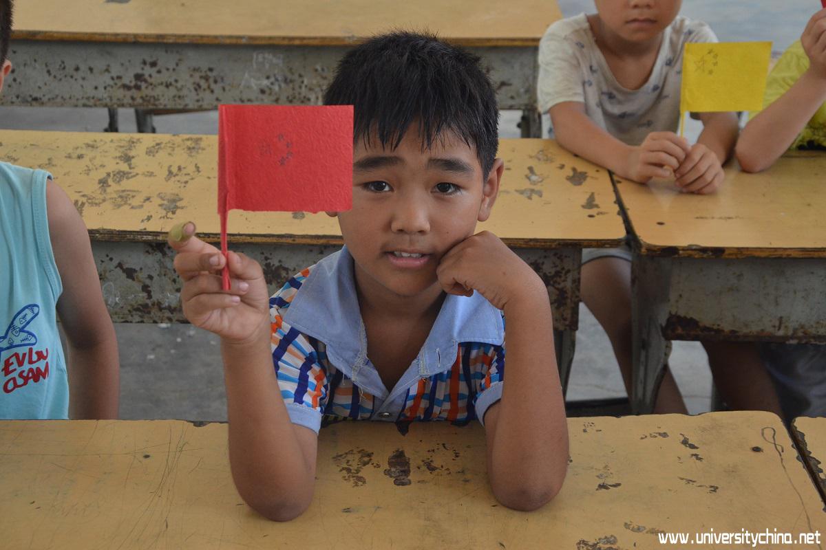 小朋友向志愿者展示自己的折纸成果，小红旗.jpg