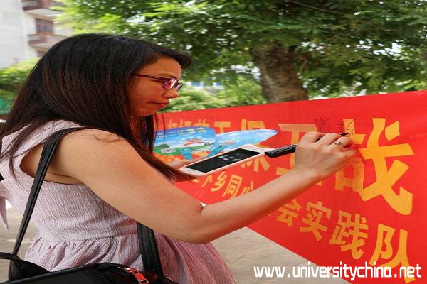 2.当地一位女老师在横幅上写了”保卫吴川蓝天，从你我做起“ 摄：王怡鑫.jpg